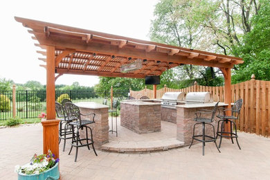 Foto de patio grande en patio trasero con cocina exterior, adoquines de ladrillo y pérgola
