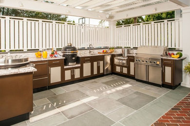 Example of a large trendy backyard brick patio kitchen design in New York with an awning