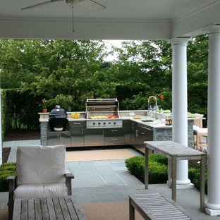 Photo of a large traditional backyard patio in New York with an outdoor kitchen, an awning and concrete pavers.