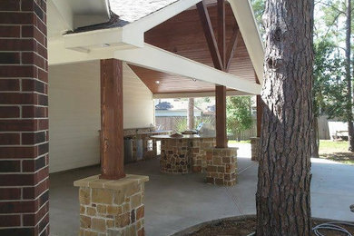 Large backyard patio photo in Houston with a roof extension