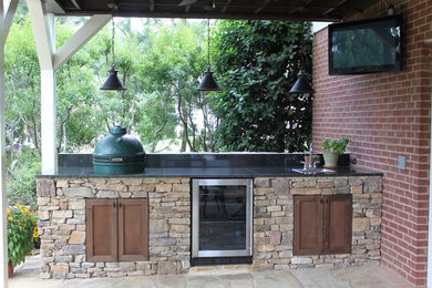 This is an example of a back patio in Birmingham with an outdoor kitchen and a roof extension.