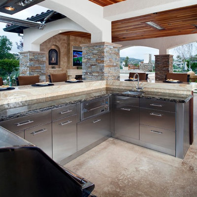 Example of a huge mountain style backyard stone patio design in Orange County with a roof extension