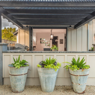 Ispirazione per un grande patio o portico country dietro casa con lastre di cemento e una pergola