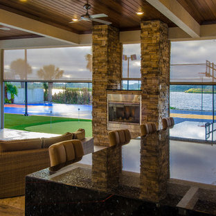 Foto di un ampio patio o portico design dietro casa con pavimentazioni in pietra naturale e un tetto a sbalzo