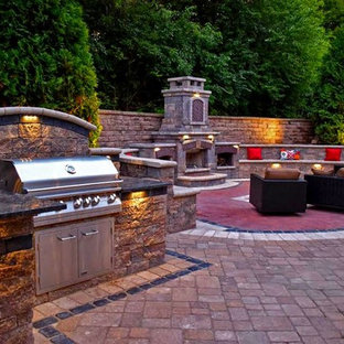 Esempio di un grande patio o portico classico dietro casa con un focolare e pavimentazioni in mattoni