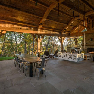 Esempio di un ampio patio o portico stile rurale dietro casa con pavimentazioni in pietra naturale
