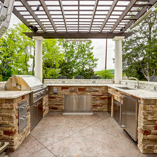 Modelo de patio tradicional, grande, en patio trasero, con cocina exterior y pérgola