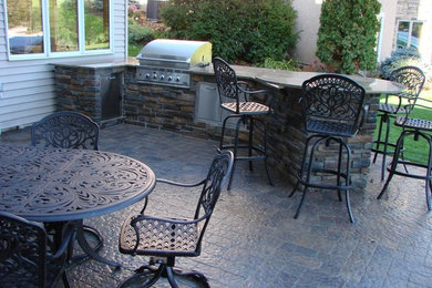 Design ideas for a medium sized traditional back patio in Minneapolis with an outdoor kitchen, stamped concrete and no cover.