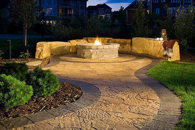 Inspiration for a mid-sized transitional backyard stamped concrete patio remodel in Dallas with a fire pit and no cover