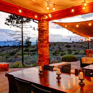 Immagine di un grande patio o portico boho chic dietro casa con lastre di cemento