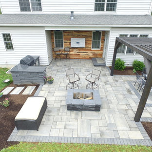 Inspiration for a backyard concrete paver patio kitchen remodel in Other with a pergola