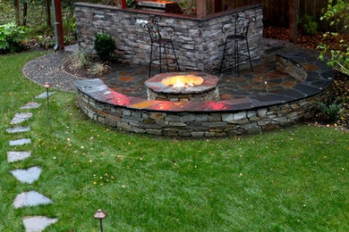Ejemplo de patio clásico grande en patio trasero con adoquines de piedra natural y cenador