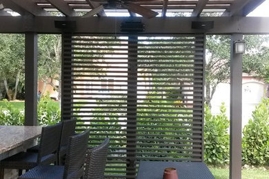 Large elegant backyard concrete paver patio kitchen photo in Miami with a pergola