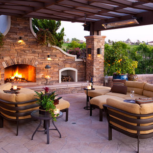 Patio - mid-sized mediterranean backyard stone patio idea in Los Angeles with a fire pit and a pergola