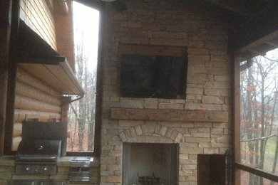 Outdoor living room / kitchen with rustic barn beam mantel