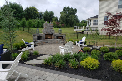 Imagen de patio de tamaño medio en patio trasero con chimenea, gravilla y pérgola