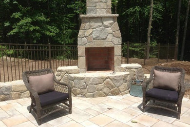 This is an example of a back patio in New York with a fire feature, no cover and concrete paving.