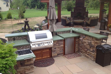 Example of a mid-sized mountain style backyard stone patio kitchen design in Philadelphia with a gazebo