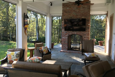 Medium sized traditional back patio in New Orleans with a fire feature, tiled flooring and a roof extension.