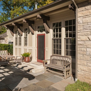 Immagine di un patio o portico country di medie dimensioni e dietro casa con un focolare, pavimentazioni in pietra naturale e una pergola