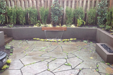 Inspiration for a mid-sized timeless backyard stone patio fountain remodel in Portland with no cover