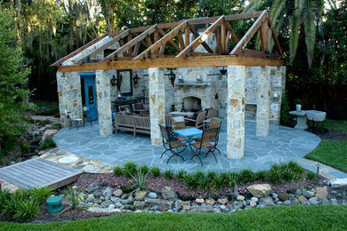 Foto de patio de estilo de casa de campo grande en patio trasero con chimenea, adoquines de piedra natural y cenador