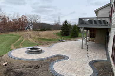Large trendy backyard concrete paver patio photo with a fire pit
