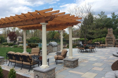 Design ideas for a large traditional back patio in Philadelphia with an outdoor kitchen, concrete paving and a pergola.