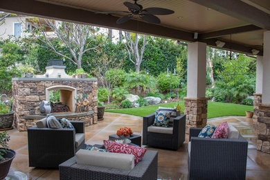 This is an example of a country back patio in Orange County with a fireplace.