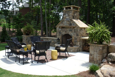 Imagen de patio clásico renovado de tamaño medio sin cubierta en patio trasero con brasero y losas de hormigón