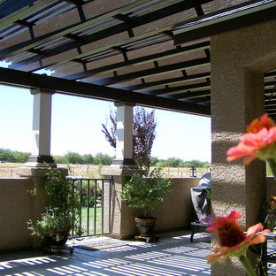 Example of a large tuscan backyard concrete patio design in Other with a roof extension