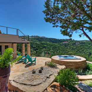 Idee per un ampio patio o portico boho chic dietro casa con pavimentazioni in pietra naturale