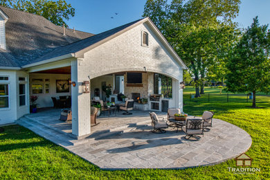 Imagen de patio rústico de tamaño medio en patio trasero y anexo de casas con chimenea