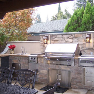 Idee per un ampio patio o portico stile americano dietro casa con lastre di cemento e un gazebo o capanno