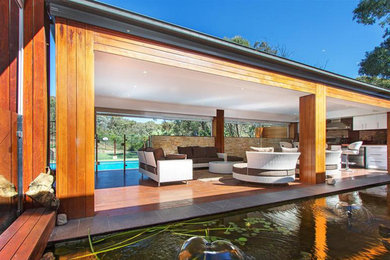 Inspiration for a large modern back patio in Canberra - Queanbeyan with an outdoor kitchen, decking and a gazebo.