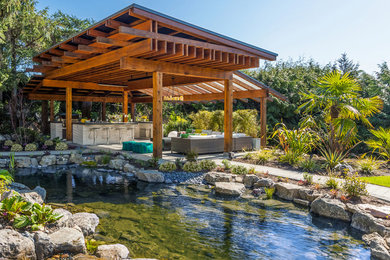 Example of an island style backyard patio design in Vancouver with a gazebo