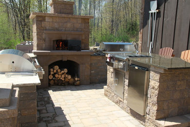 Modelo de patio clásico de tamaño medio sin cubierta en patio trasero con cocina exterior y adoquines de ladrillo