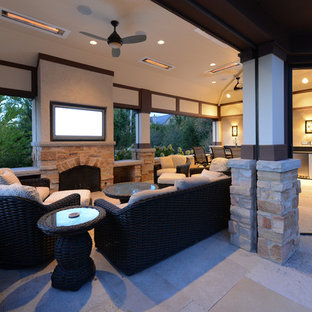 Immagine di un patio o portico american style di medie dimensioni e dietro casa con pavimentazioni in pietra naturale e un tetto a sbalzo
