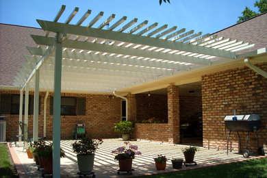Foto di un patio o portico nel cortile laterale con lastre di cemento e una pergola
