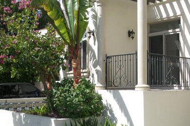 Patio - small mediterranean front yard concrete paver patio idea in Los Angeles with a pergola