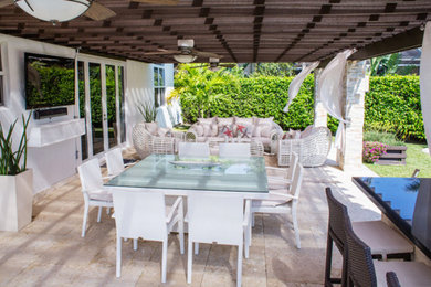 Example of a mid-sized transitional backyard tile patio container garden design in Miami with a gazebo