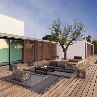 This is an example of a medium sized coastal back patio in London with decking and no cover.