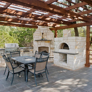 Foto di un ampio patio o portico american style dietro casa con piastrelle e una pergola