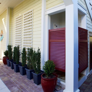 Immagine di un patio o portico stile marino di medie dimensioni con pavimentazioni in mattoni
