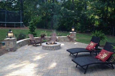 Example of a mid-sized mountain style backyard stone patio design in Atlanta with a fire pit and no cover