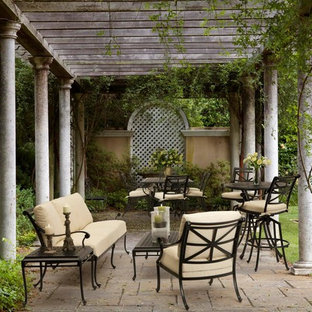 Inspiration for a mid-sized timeless courtyard brick patio remodel in DC Metro with a pergola