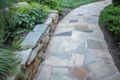 Imagen de patio clásico renovado de tamaño medio sin cubierta en patio trasero con adoquines de piedra natural