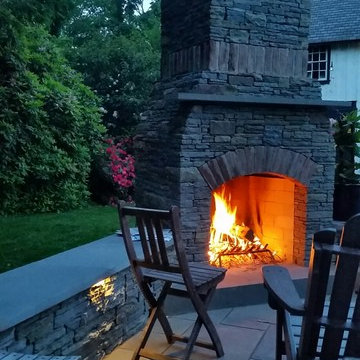 Outdoor Stone Fireplace and entertaining space with seatwalls