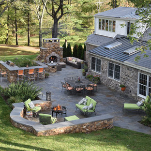 Immagine di un grande patio o portico american style dietro casa con un focolare, pavimentazioni in cemento e nessuna copertura