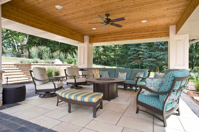 Foto de patio tradicional de tamaño medio en patio trasero con brasero, adoquines de piedra natural y cenador